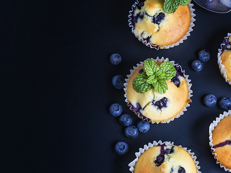 Blueberry muffins with powdered sugar and fresh berries